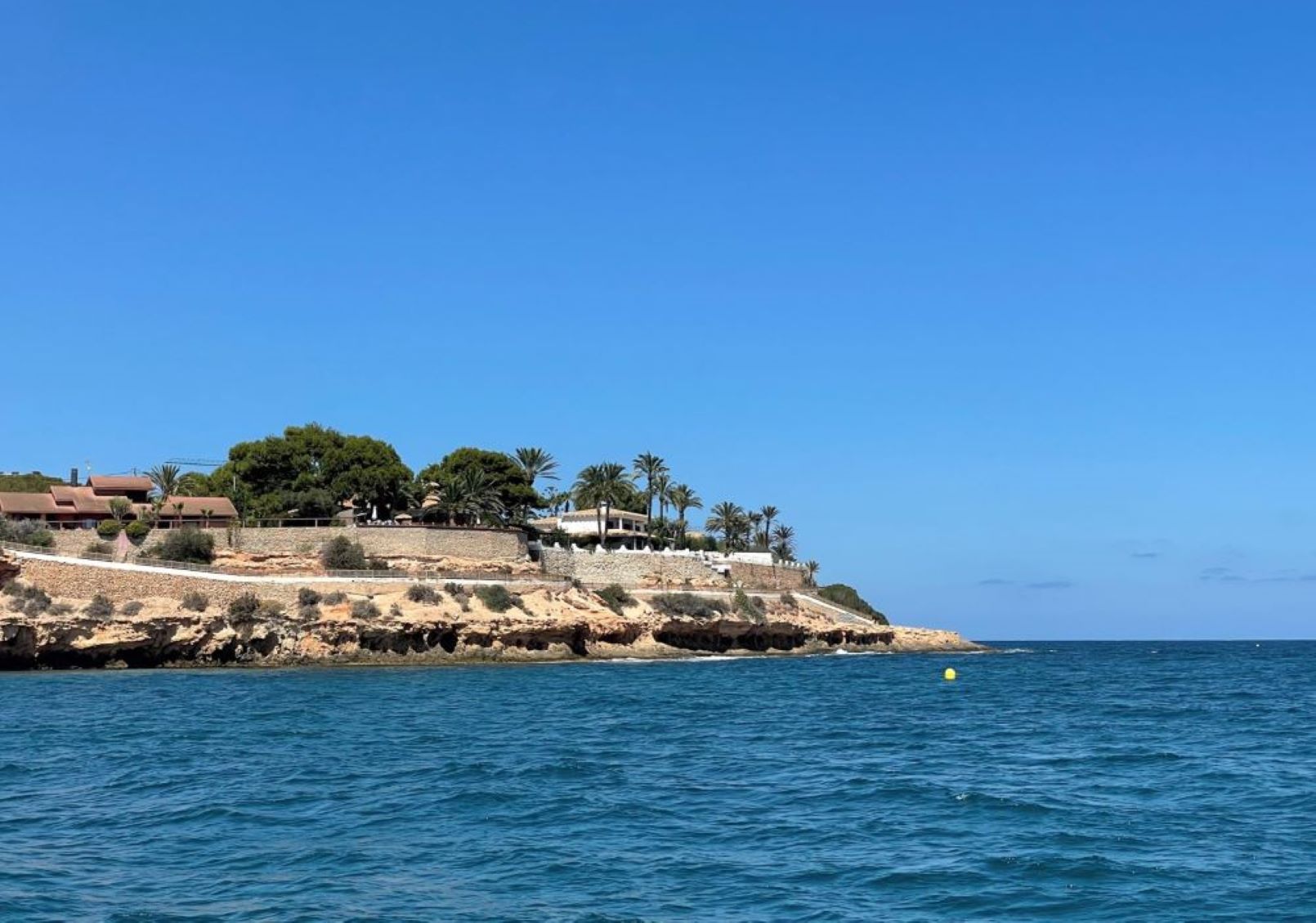 Cabo Roig desde el mar – Costa Blanca Vista de Cabo Roig desde el mar, con sus acantilados, casas y palmeras sobre el Mediterráneo