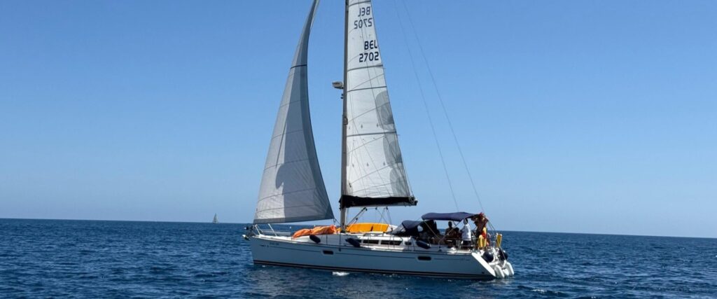 Navegación en mar tranquilo Velero navegando sobre un mar plano y tranquilo bajo un cielo despejado en la Costa Blanca.